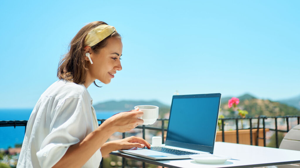 A luxury travel advisor working in a beautiful location, satisfied with the travel incentive program at Andavo Travel